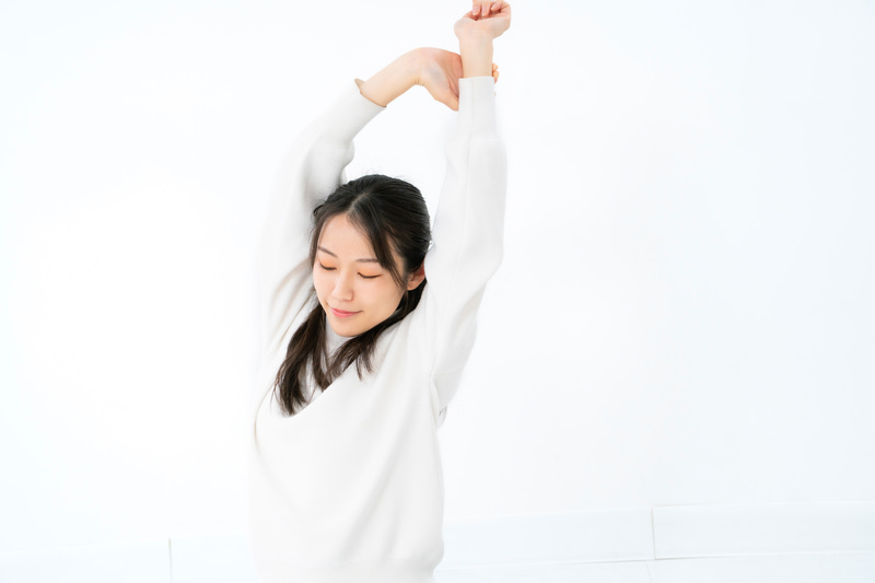 背伸びをする女性