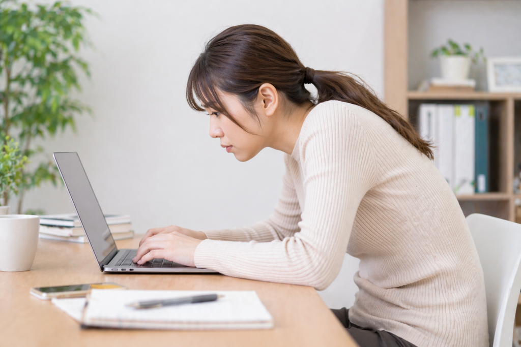 猫背で作業をする女性